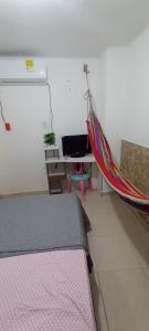 a bedroom with a bed and a desk and a hammock at Encantadora casa con ambiente guajiro #3 in Barranquilla