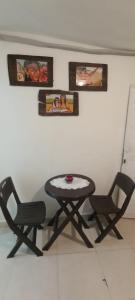a table and two chairs in front of a wall at Encantadora casa con ambiente guajiro #3 in Barranquilla