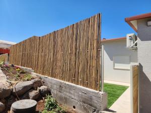 a wooden fence in front of a house at וילת הנחלה למשפחות Nahala Villa in Shadmot Devora