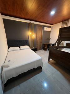 1 dormitorio con cama blanca y techo de madera en Hotel Almalu en Aguachica