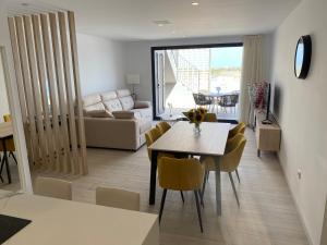 a living room and dining room with a table and chairs at Jacuzzi Penthouse appartement Santa Rosalia Lake & Life Resort Murcia Golf in Los Alcázares