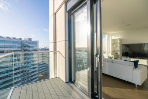 a balcony with a couch and a television on a building at Amazing 1BR wbalcony & view, Acton, Smarthost in London