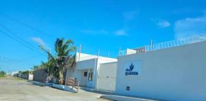 a building with a palm tree next to a street at FLAT 104 Luis Correia Vila Atlântida in Luis Correia