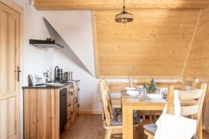 una cucina e una sala da pranzo con tavolo in legno di Dom Tatrzański Ewa Deluxe a Kościelisko