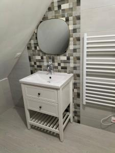 bagno con lavandino bianco e specchio di Chez Pascale & Christian a Langoat