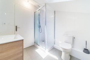 La salle de bains blanche est pourvue d'une douche et de toilettes. dans l'établissement Le Pelisson 6 pers fonctionnel Gratte Ciel, à Villeurbanne