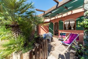 een patio met een tafel en stoelen op een huis bij Gavila's Residenza Turistico Alberghiera in Porto Azzurro