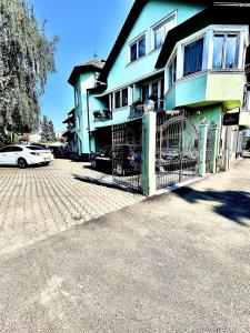 a blue house with a gate in front of it at Pensiunea Curtea Bavareza in Târgu-Mureş