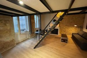 a loft with a staircase and a living room with a table at Carmélites-Charmant 4 pers-pentes Croix Rousse in Lyon