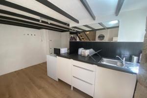 a kitchen with white cabinets and a sink at Carmélites-Charmant 4 pers-pentes Croix Rousse in Lyon