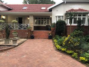 a house with a brick driveway in front of it at St John`s Guest House in Pietermaritzburg