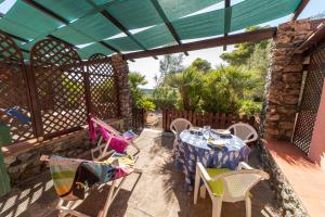 un patio con mesa, sillas y una valla en Gavila's Residenza Turistico Alberghiera en Porto Azzurro