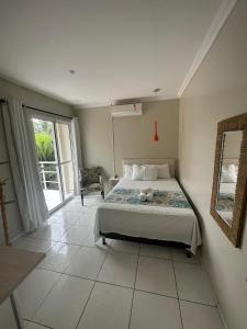 1 dormitorio con 1 cama y 1 habitación con ventana en Riacho do Recanto Pousada, en Barreirinhas