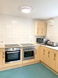 a kitchen with a stove and a microwave in it at ALTIDO Cosy rooms in Southampton in Southampton