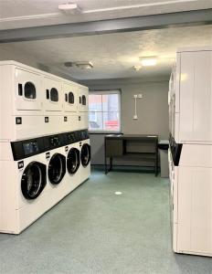 a laundry room with two washing machines and a table at ALTIDO Cosy rooms in Southampton in Southampton