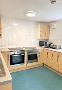 a large kitchen with wooden cabinets and appliances at ALTIDO Cosy rooms in Southampton in Southampton