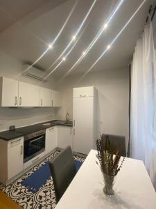 a kitchen with white cabinets and a table with chairs at Home Sweet Home - Stephansdom in Vienna