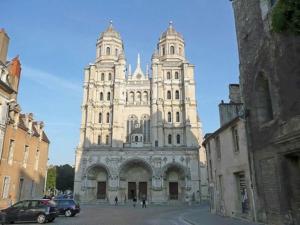 a large white building with two towers on a street at Le Bohème chic : au coeur du centre historique in Dijon +8 photos