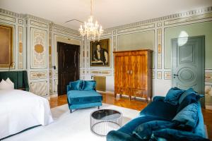 a bedroom with a bed and a couch and chairs at Georgi Schloss - Boutique Hotel in Ehrenhausen