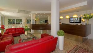 ein Wohnzimmer mit roten Möbeln und einer Bar in der Unterkunft Hotel Scandinavia in Marina di Massa