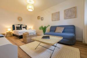 a living room with a blue couch and a bed at Le Bohème chic : au coeur du centre historique in Dijon
