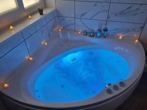 a blue tub with lights in a bathroom at Le Bohème chic : au coeur du centre historique in Dijon