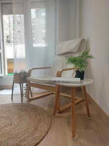 a bed with a table with a plant on it at Apartamento Brisa de Santander in Santander