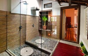 a glass shower in a bathroom with a potted plant at Sarang Paloh Heritage Stay in Ipoh