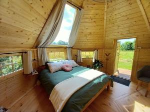 1 dormitorio con 1 cama en una cabaña de madera en Insolite: Le Kota du Lutin Many, en Saint-Christophe-sur-Condé