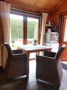 uma mesa e cadeiras numa cozinha com uma janela em House Rhodopi em Maldegem