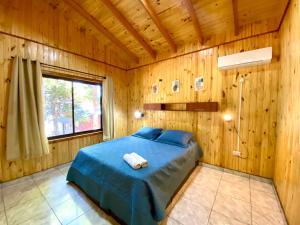 a bedroom with a bed in a wooden room at Blusky Lodge in Puerto Iguazú