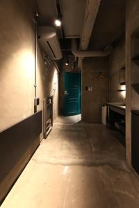 - un couloir sombre avec une porte verte dans la chambre dans l'établissement SHIN kyoto, à Kyoto