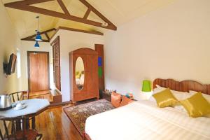 a bedroom with a bed and a table in it at Sarang Paloh Heritage Stay in Ipoh