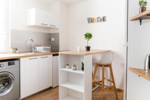 a kitchen with white cabinets and a counter top at Studio coquet calme et lumineux - Part Dieu in Lyon