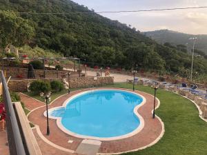 a swimming pool with a mountain in the background at Case Magliolo in Cefalù