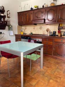 kuchnia ze stołem i czerwonymi krzesłami w obiekcie Ester Lakehouse, graziosa casa indipendente w mieście Lierna