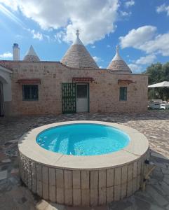 dom z basenem przed nim w obiekcie Villa Il Leccio - Trulli w mieście Cisternino
