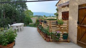 un giardino con piante in vaso e una recinzione in legno di Studio saisonnier a La Roquette-sur-Siagne