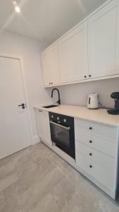 セント・アイヴスにあるHarbour View Guest Houseの白いキャビネットと黒の電化製品が備わるキッチン