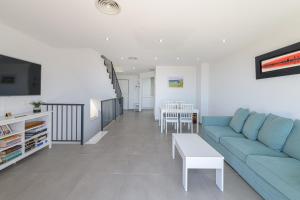 WintowinRentals New and Sea View في توري دي بيناغالبون: غرفة معيشة مع أريكة زرقاء وطاولة