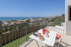 a white table and chairs on a balcony with the ocean at WintowinRentals New and Sea View in Torre de Benagalbón