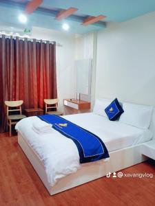 1 dormitorio con 1 cama con manta azul y blanca en Điêu Thuyền Motel en An Khê