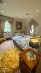 a bedroom with a bed and a table with a lamp at Errew Lodge in Mohill