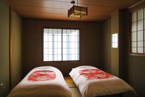 dwa łóżka w pokoju z dwoma oknami w obiekcie Koizumiya - Vacation STAY 14238v w mieście Yuzawa