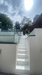 a set of stairs on a house with the sun in the background at Luxurious cabin with desk & mini library in Parkstone