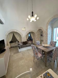 a living room with a table and chairs and a couch at Trullo Gnoffa in La Correggia