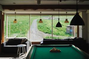 a living room with a pool table and a large window at Koizumiya - Vacation STAY 14238v in Yuzawa