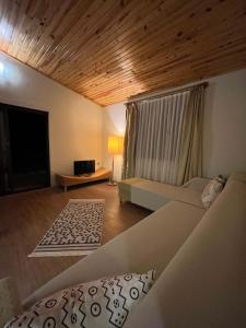 a living room with a couch and a tv at Kibala Hotel in Cıralı