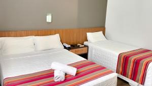 a hotel room with two beds with towels on it at Itajaí Express Residence in Itajaí