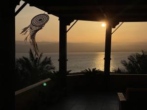 uma vista para o oceano ao pôr-do-sol a partir de uma casa em The Precious Guesthouse em Sowayma